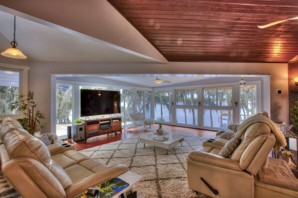 Living Area with floor-to-ceiling windows, big screen smart TV, 6 recliners