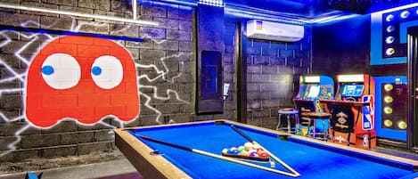 Game room includes pool table and fun game arcade.