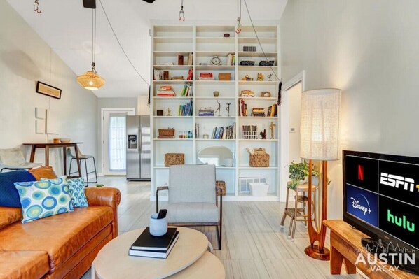 Living room with sleeper sofa, TV, full bookshelf and bike hooks!