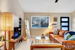 Living room with sleeper sofa, TV, full bookshelf and bike hooks!