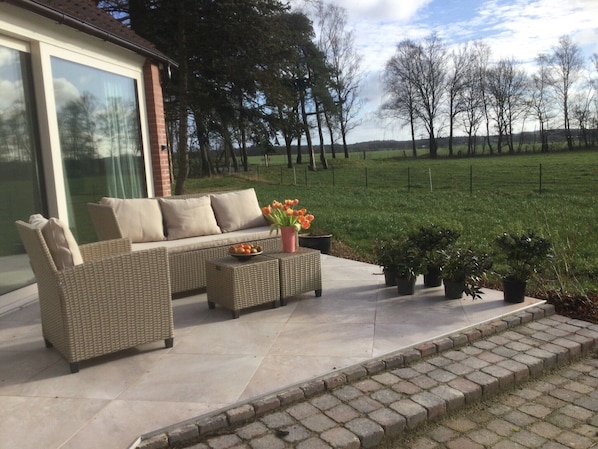 The terrace with a view on the meadows and woods.