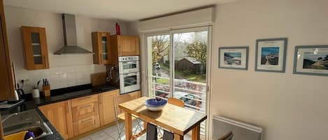 Kitchen with large windows overlooking main house and parking area