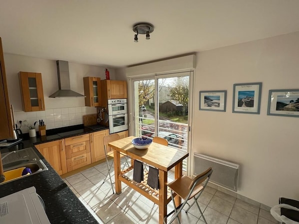 Kitchen with large windows overlooking main house and parking area