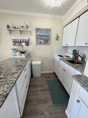 Beautifully decorated kitchen with stove/oven, microwave, and refrigerator.