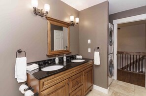 Upper-level bathroom w/ laundry facilities.