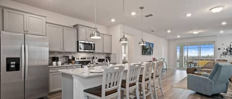 Modern Style Downstairs Area with Kitchen, Barstool Seating, and Living Room Lounge