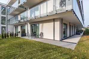 Exterior view of an apartment complex with balconies and green lawns.