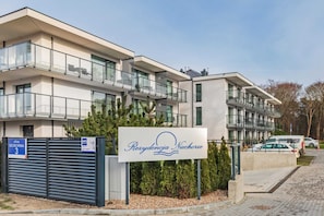 Exterior shot of the apartment complex, with a well-maintained lawn and surrounding trees.