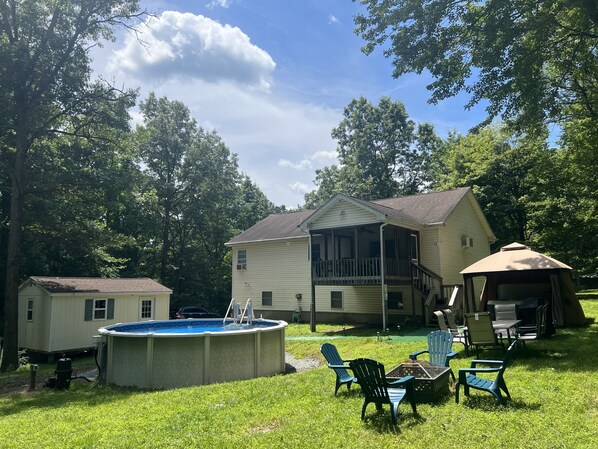 View of the backyard where the pool/ hottub grill/ outdoor dining set & firepit.