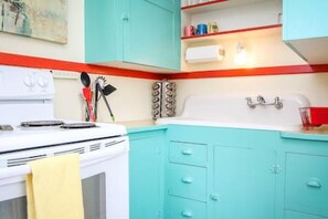 Darling kitchen with electric stove, microwave, Keurig, and an option to purchase wine.