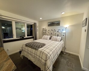 Queen bed in Baked Alaska Room Large windows with forest view.