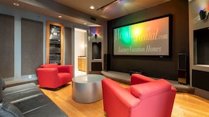 Home theater w/ comfortable seating, projector, sound system, & kitchenette