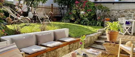 Jardin avec terrasse pour la farniente et coin repas.