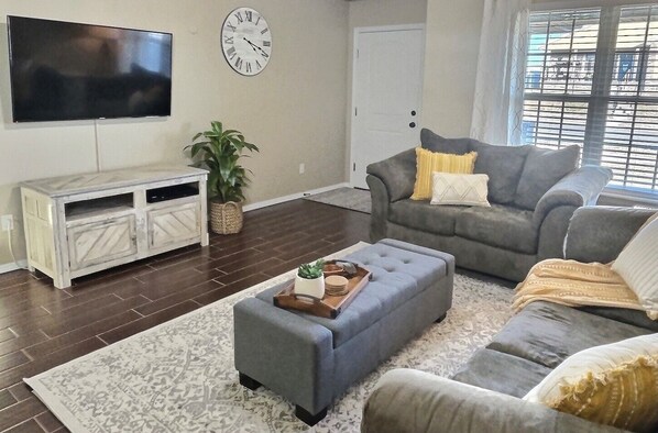 Living Room with comfortable furniture, 55" Smart TV and Blu-ray Player.