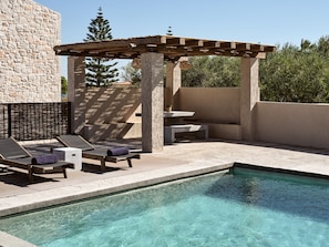 Premium sun loungers and authentic settings surround the pool area. 