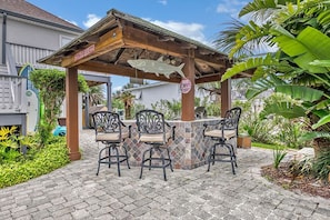 Tiki hut w/ bar seating, gas grill, dual sink, mini frig, outdoor dining tables.