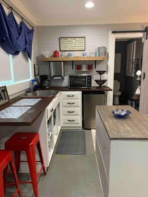 The kitchenette countertops are uniquely crafted from the home's original doors, adding a touch of charm.”