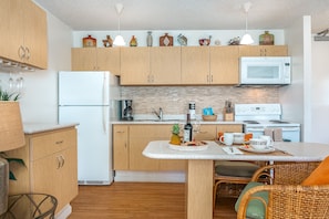 Fully equipped kitchen with dining counter, and 2 comfortable chairs.