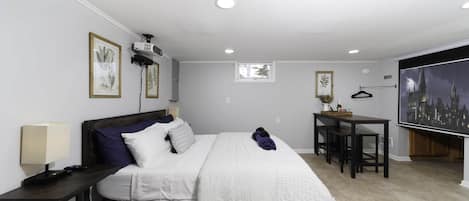 The bedroom features black-out blinds, a projector, Roku soundbar and an 84" screen