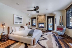 Main level primary suite with a cozy fireplace and a private balcony.