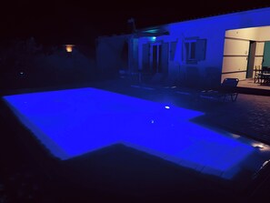 The bright blue of the pool light give off a warm summer evening glow