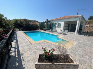 A large patio surrounds the pool area