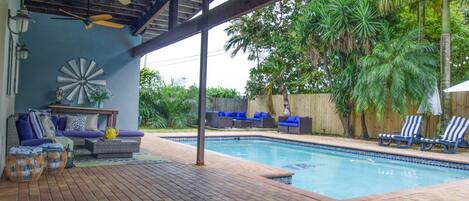 Tropical Backyard with 24/7 heated pool and full outdoor kitchen with gas grill.