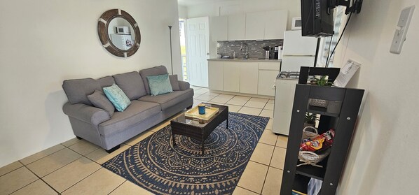  Open spacious living area with fan, smart TV Wi-Fi and access to balcony.