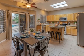 Doors between the kitchen and dining area access the backyard oasis with resort amenities.