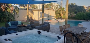 Hot tub, fire pit, grill, and comfy furniture on the pool patio