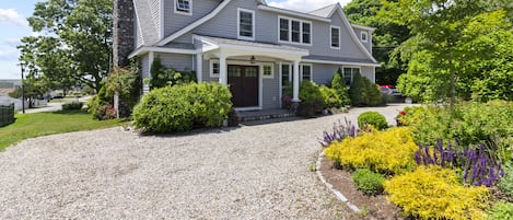 Front of house. White pebble semicircular driveway.