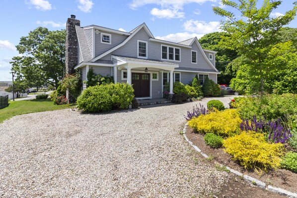 Front of house. White pebble semicircular driveway.