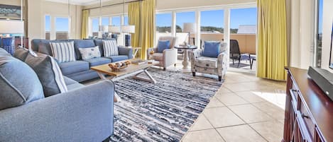 Living Room | Breathe Easy Rentals - Blues and yellows make this living room come to life with the feel of the beach. Large area for everyone to have a place to sit and relax.