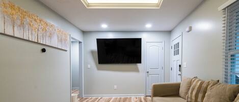Our Spacious living room fitted with a 70 in smart tv and recessed overhead lighting.
