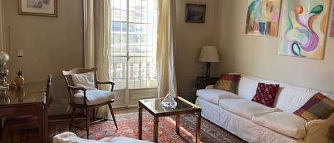 Living Room is full of sunlight, a desk to work and adjacent TV living room area