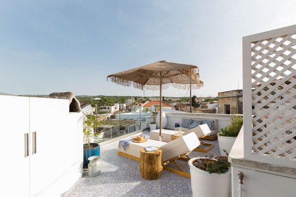 The roof terrace with two cosy sunbeds and umbrell