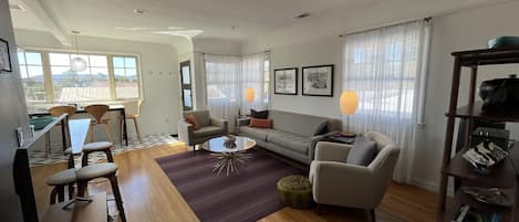 Open floor plan, with a flatscreen TV Roku device and Klipsch Bluetooth speaker