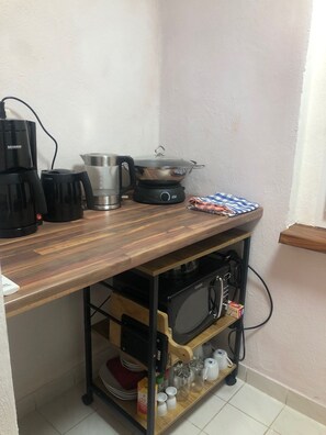 Arbeitsplatte mit Kaffee, Filtertüten, Kaffee- und Wasserkocher, Kochplatte, Wok