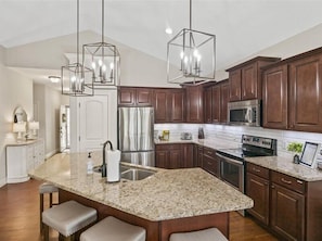 Fully stocked kitchen with granite countertops and stainless steel appliances