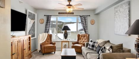 Living room with pull out sofa bed and 65" smart TV.