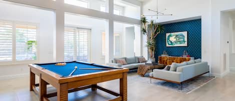 Main Living Room has designer billiards table, seating area, & art wall