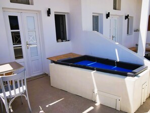 Patio with hot tub and entrance to the property