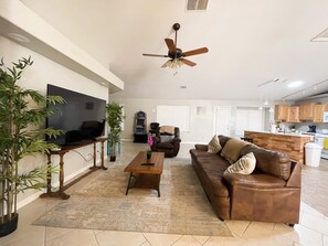 Living room has a comforter, recliner and TV