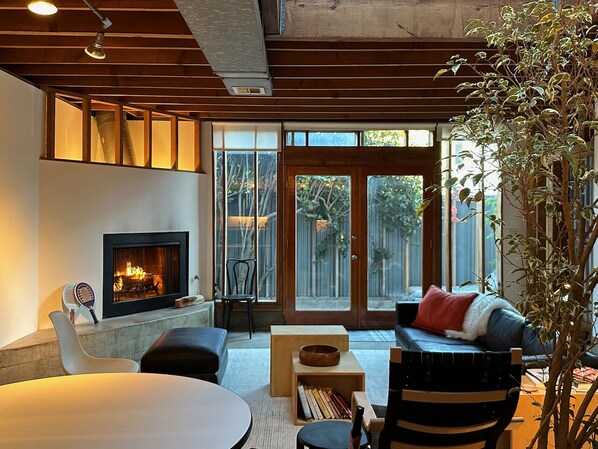 Living room with fireplace looking onto the patio garden. 
