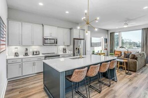 Fully equipped kitchen with stainless steel appliances, plenty of counter space, and island seating