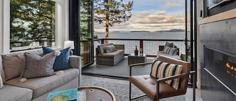 Cover photo - There is a cozy fireplace in the living room with an accordion glass wall opening the entire house to the stunning Salish Sea 

**Not suitable for children under 16 due to high bank waterfront.**