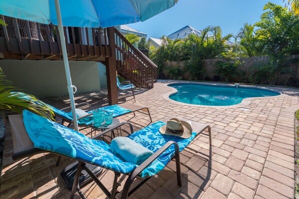Pool deck with lounge chairs and umbrella stand