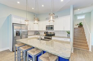 View of kitchen with plentyof cabinet space and the stairway just off to the right
