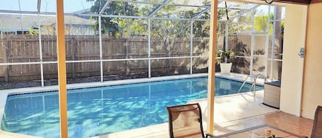 Private saltwater pool with screened in enclosure from back patio