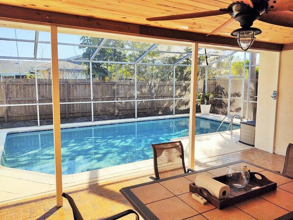 Private saltwater pool with screened in enclosure from back patio